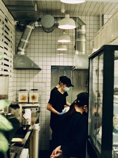 man in blue t-shirt standing in front of kitchen counter