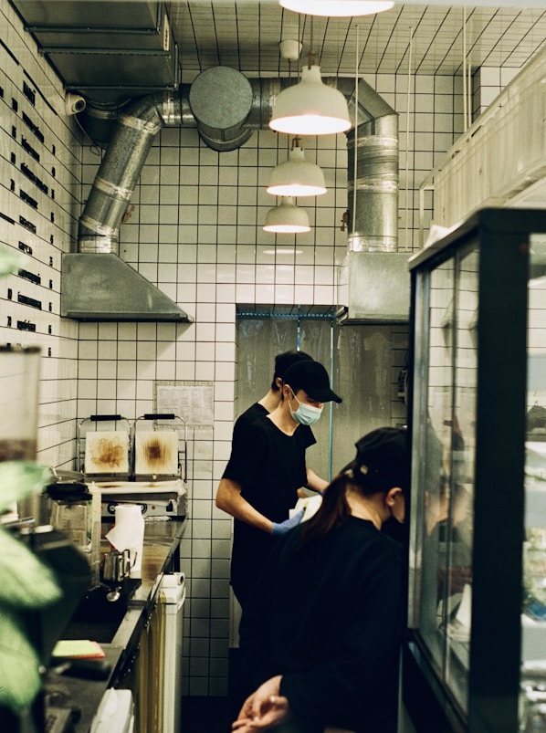 man in blue t-shirt standing in front of kitchen counter