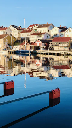 A serene whitewashed house by the sea in a car-free village with boats anchored quietly nearby.