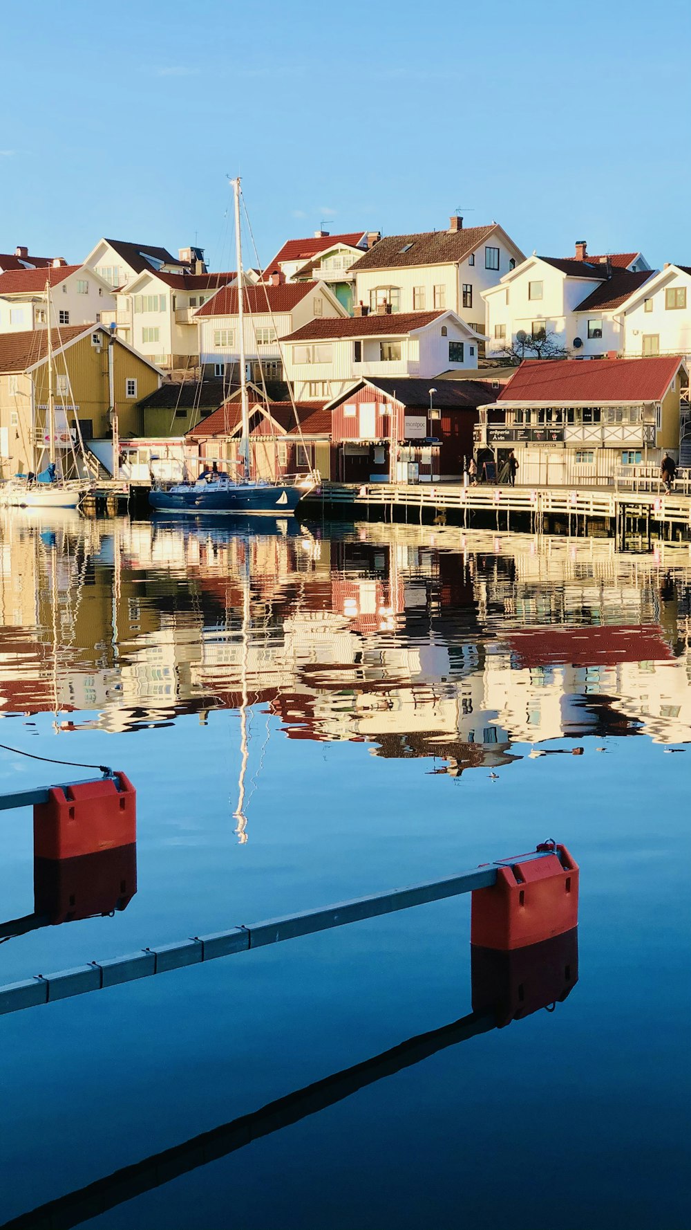 red and blue houses beside body of water during daytime