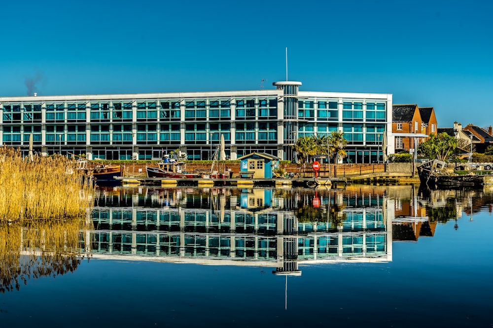 white and blue concrete building near body of water during daytime