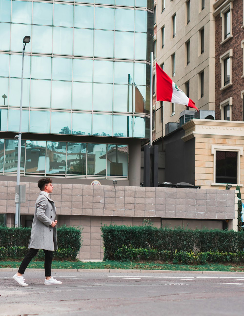 woman in white coat standing near building during daytime