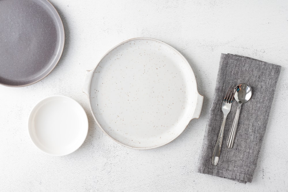 white round plate beside fork and bread knife