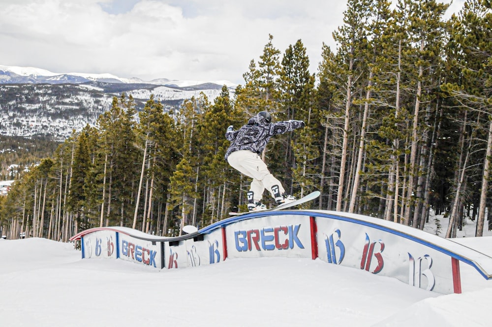 uomo in giacca nera che cavalca sullo snowboard durante il giorno