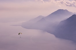 person in parachute over mountains during daytime
