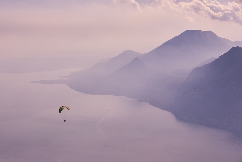 person in parachute over mountains during daytime