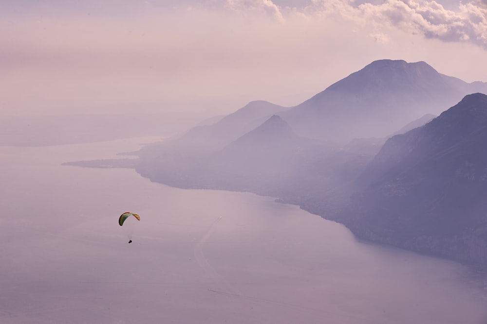 Persona en paracaídas sobre las montañas durante el día