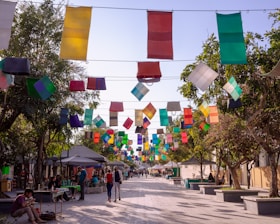 A vibrant street scene with artists setting up colorful booths and families enjoying the festival atmosphere.