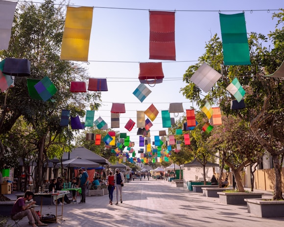 A vibrant street scene with artists setting up colorful booths and families enjoying the festival atmosphere.