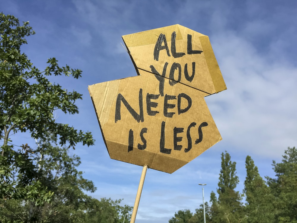 Un letrero de cartón que dice que todo lo que necesitas es menos