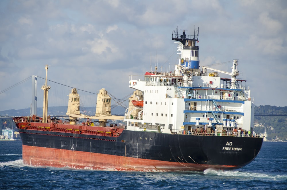 blue and white ship on sea under white clouds during daytime