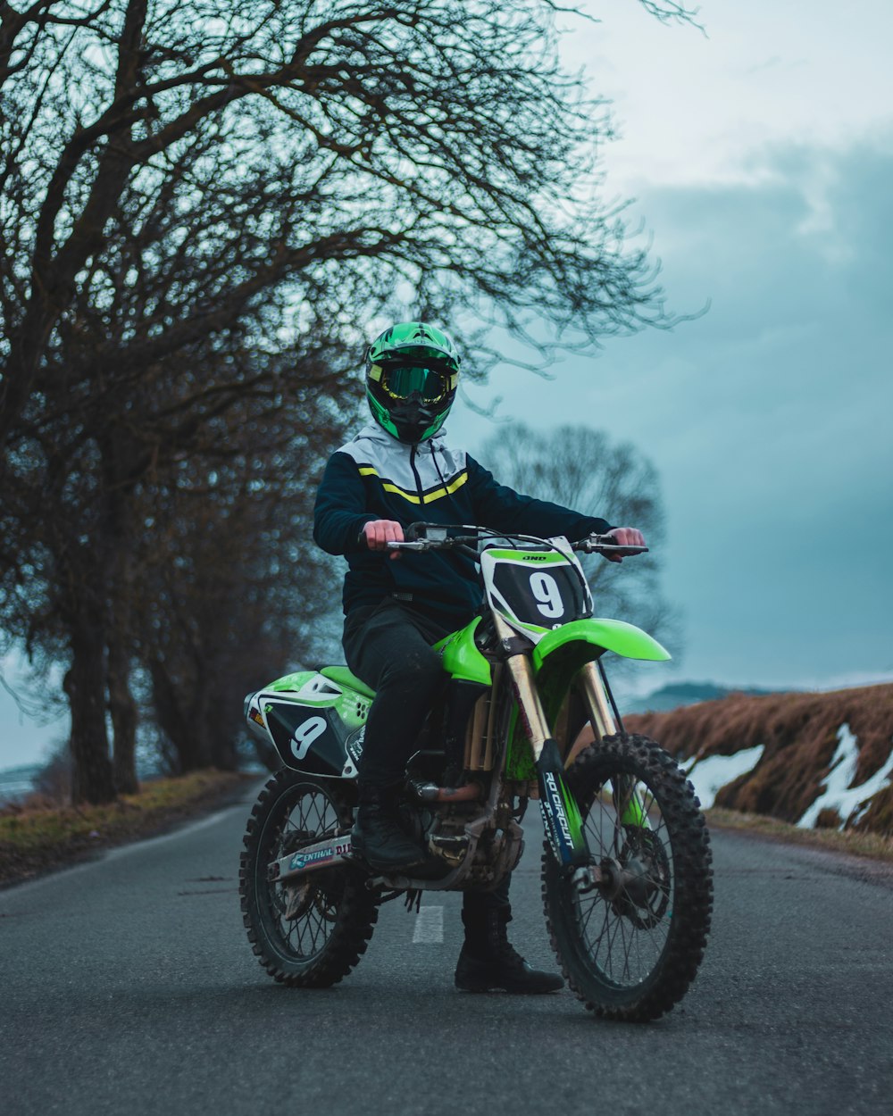 man in green helmet riding green and black motorcycle