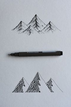 black and gray click pen on white printer paper