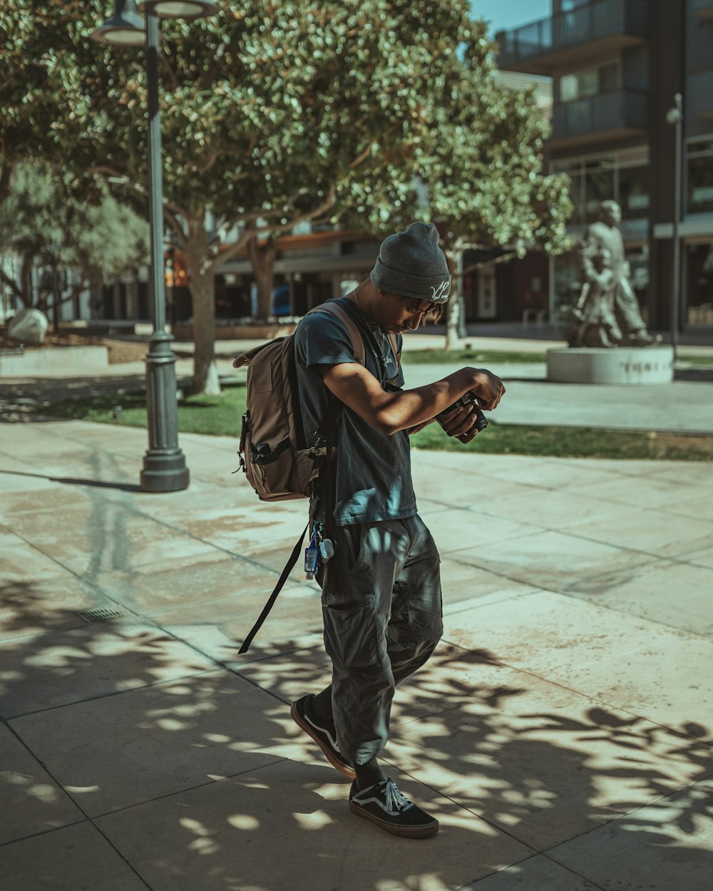 man in black and white camouflage jacket and pants standing on sidewalk during daytime