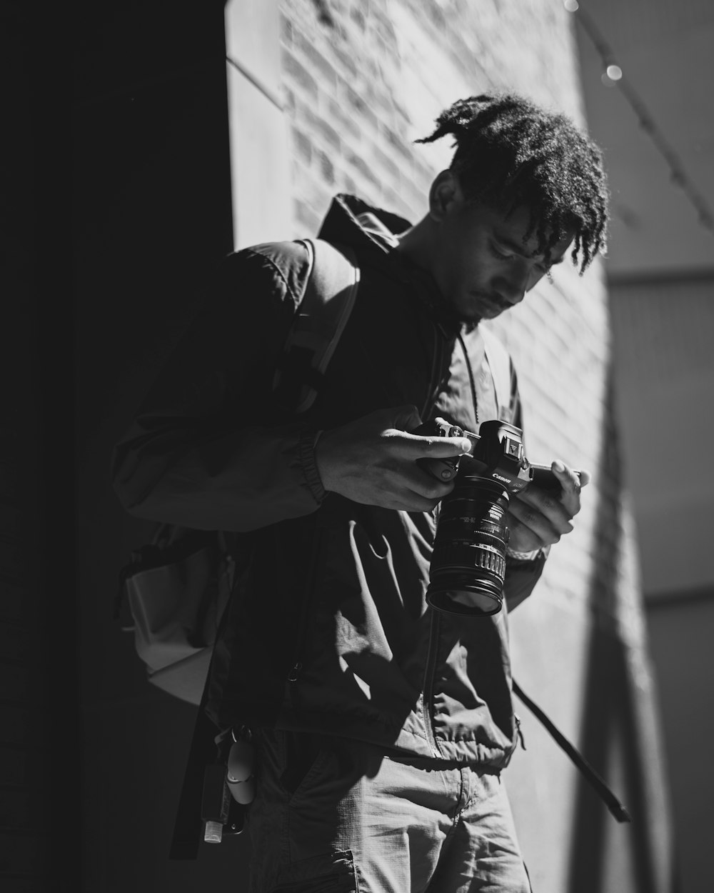 man in black jacket holding dslr camera