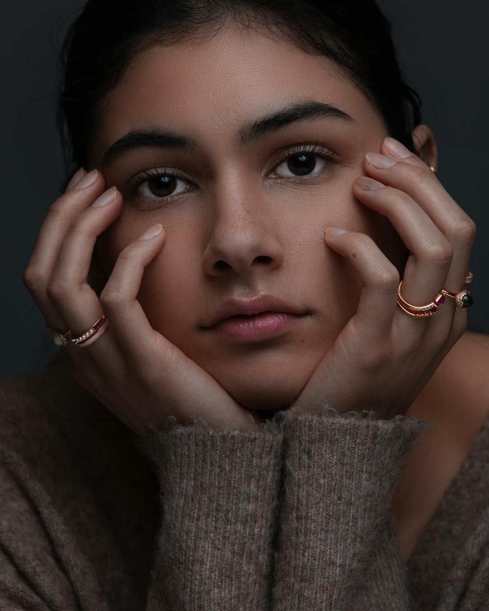 woman in gray sweater wearing gold ring
