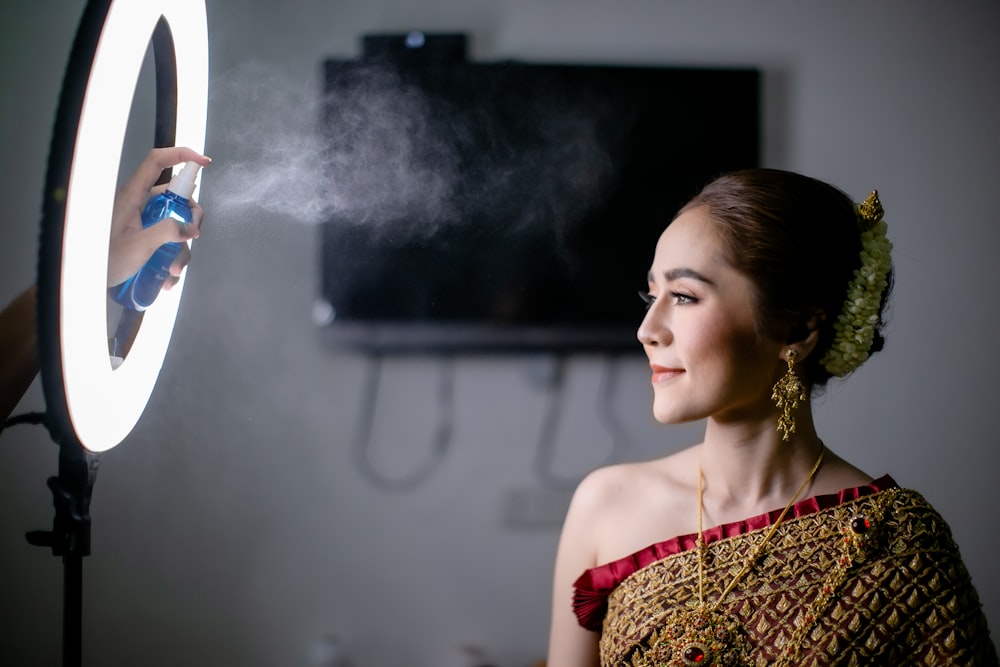 woman in red and brown dress holding white and blue bottle