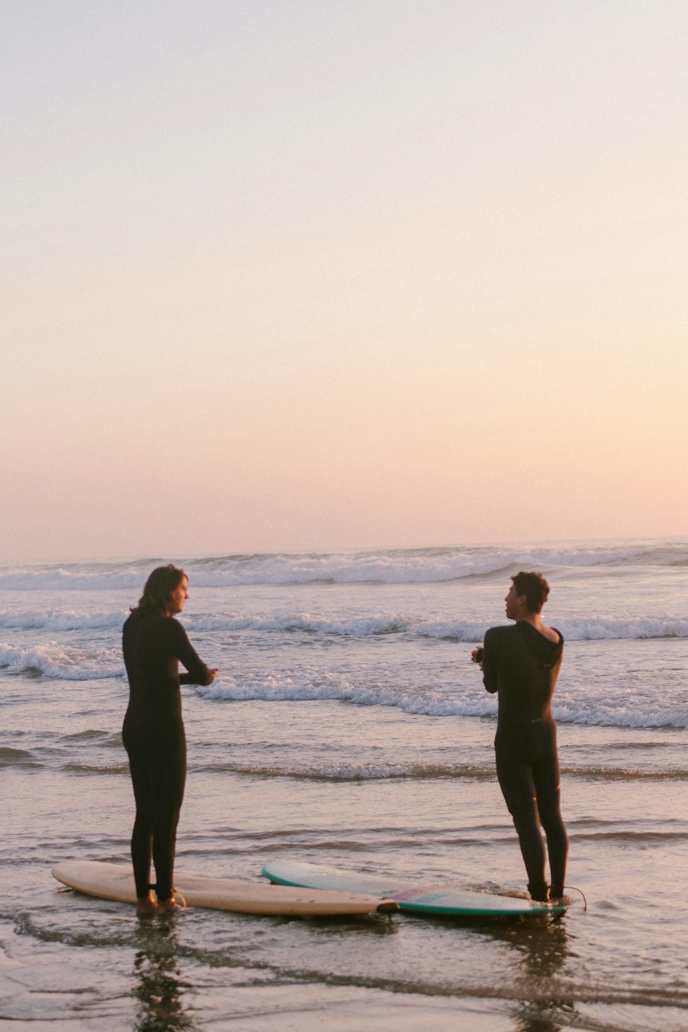 couple standing on beach during daytime