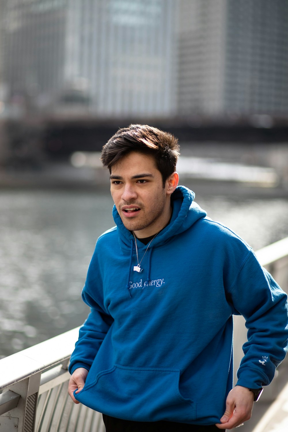 man in blue hoodie standing near body of water during daytime