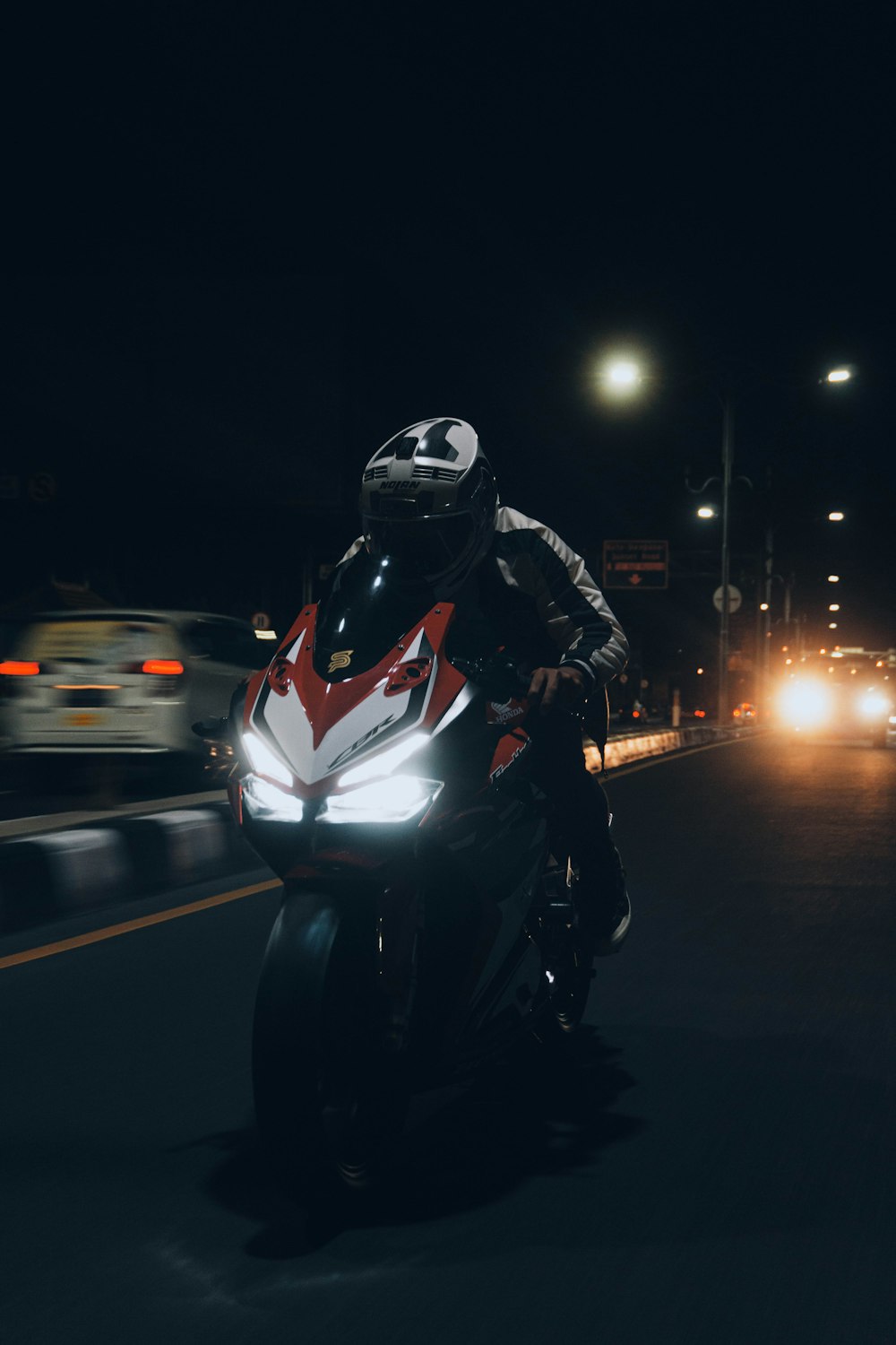 homme en veste noire conduisant une moto pendant la nuit