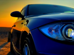 Close-up of a polished red Ferrari reflecting Miami skyline at sunset.