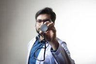 person in white shirt holding black and silver headphones