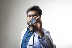 Smiling male doctor wearing a white coat and stethoscope.