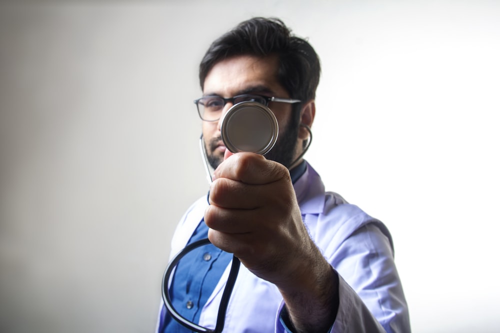 person in white long sleeve shirt holding magnifying glass