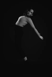 A graceful pose of Deja Demuré against a marble-textured backdrop with soft metallic accents.