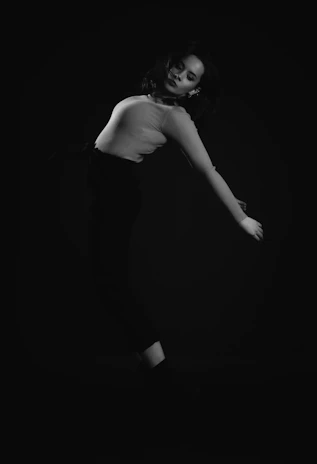 A graceful pose of Deja Demuré against a marble-textured backdrop with soft metallic accents.