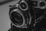 An artistic black-and-white close-up of a camera lens capturing a cinematic moment.