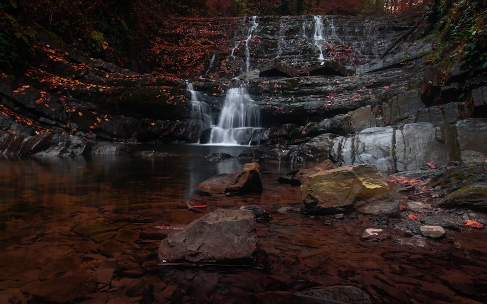 water falls on brown rocky mountain