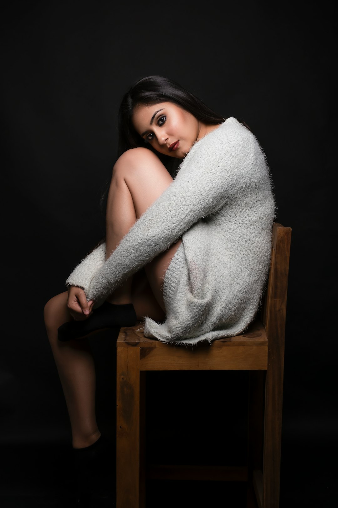 woman in white bath towel sitting on brown wooden chair