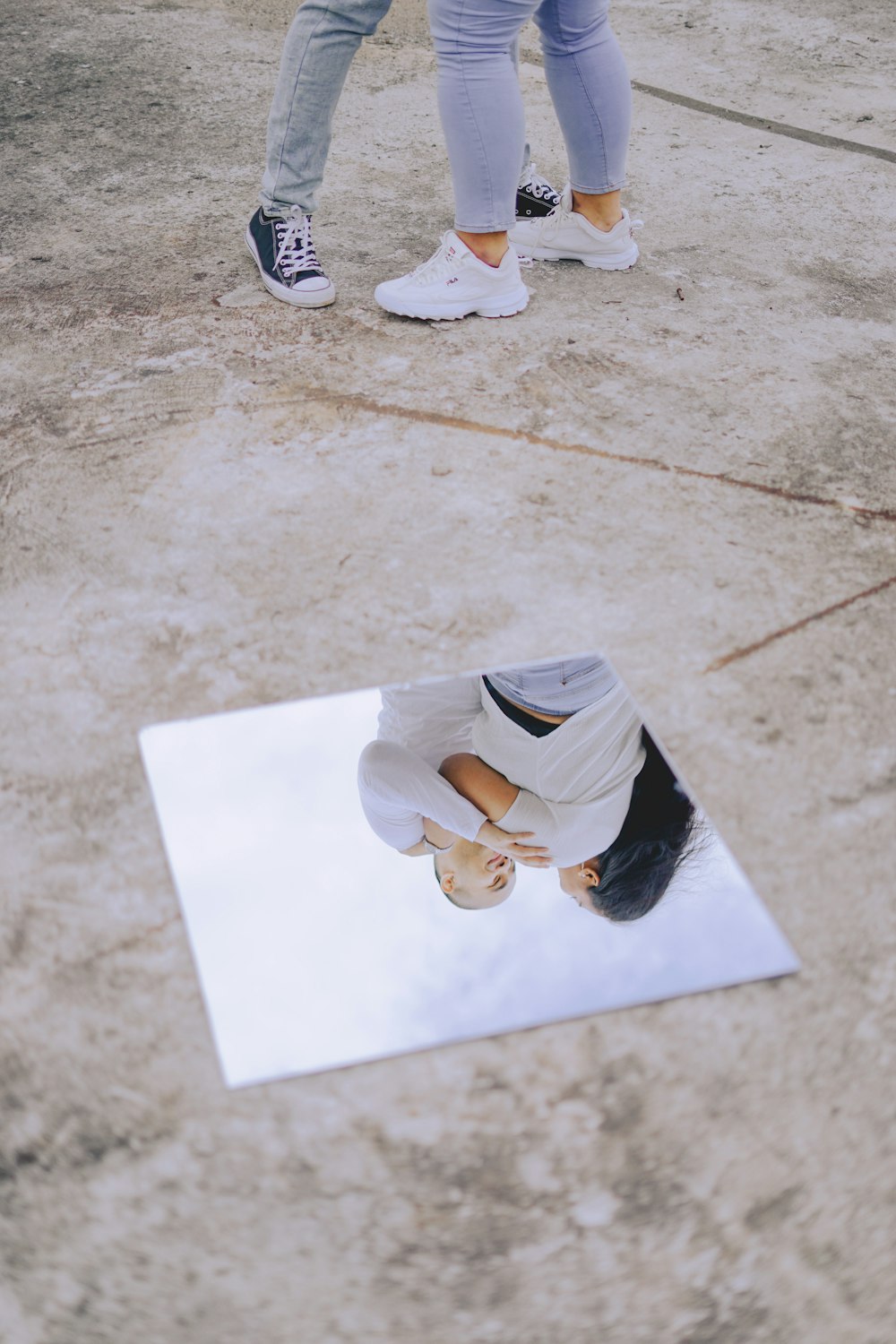 person in white sneakers standing on white floor