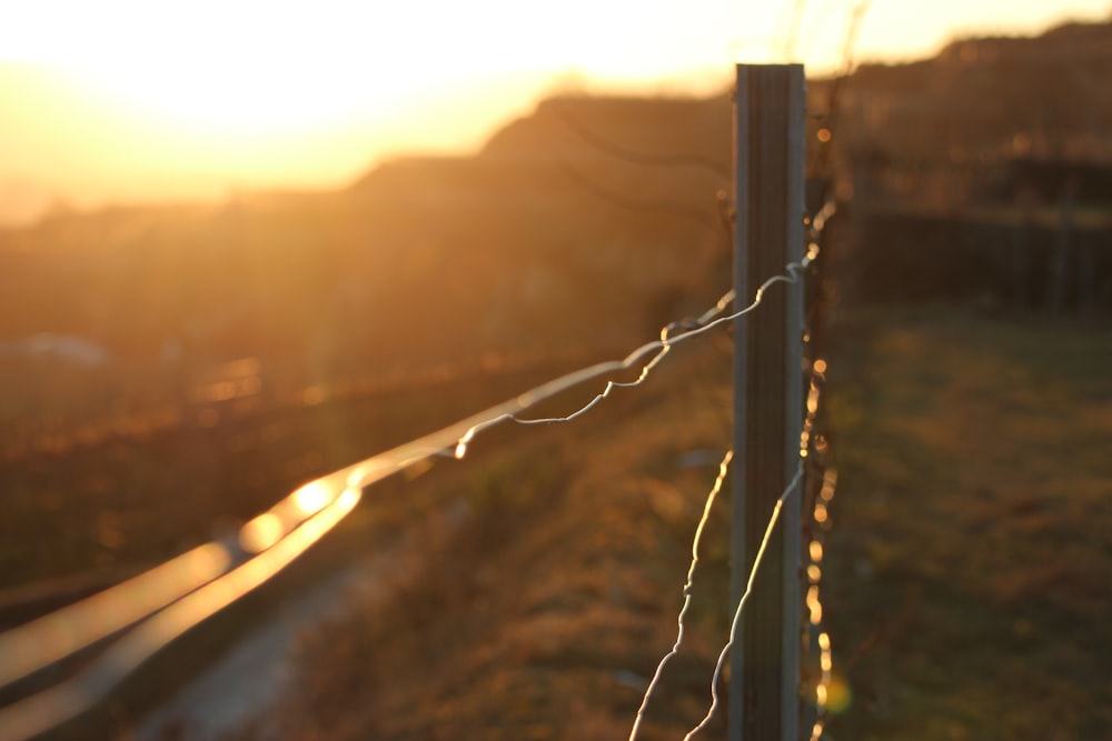 Grauer Metalldrahtzaun bei Sonnenuntergang