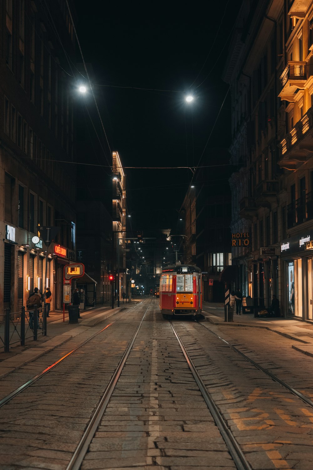 red and white train on the street during night time