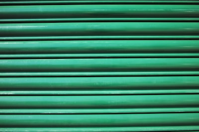 Close-up of freshly printed standing seam metal panels stacked outdoors with Sudbury landscape in the background.