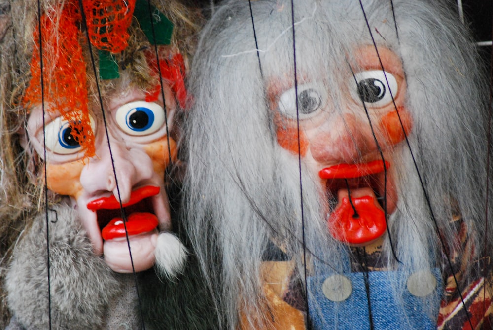 a couple of creepy looking dolls hanging from a wire fence