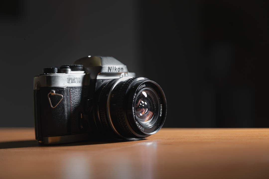 black and silver nikon dslr camera on brown wooden table