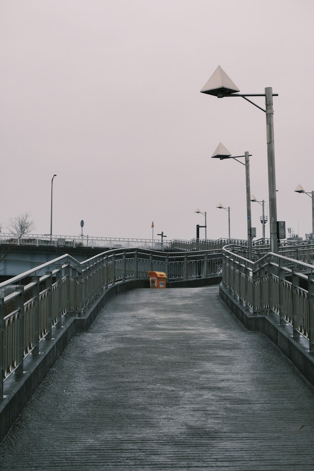 schwarz-gelbes Straßenschild auf grauer Betonbrücke tagsüber