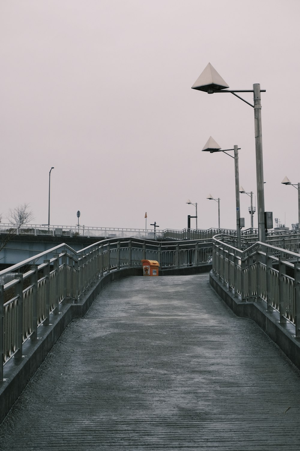 black and yellow road sign on gray concrete bridge during daytime