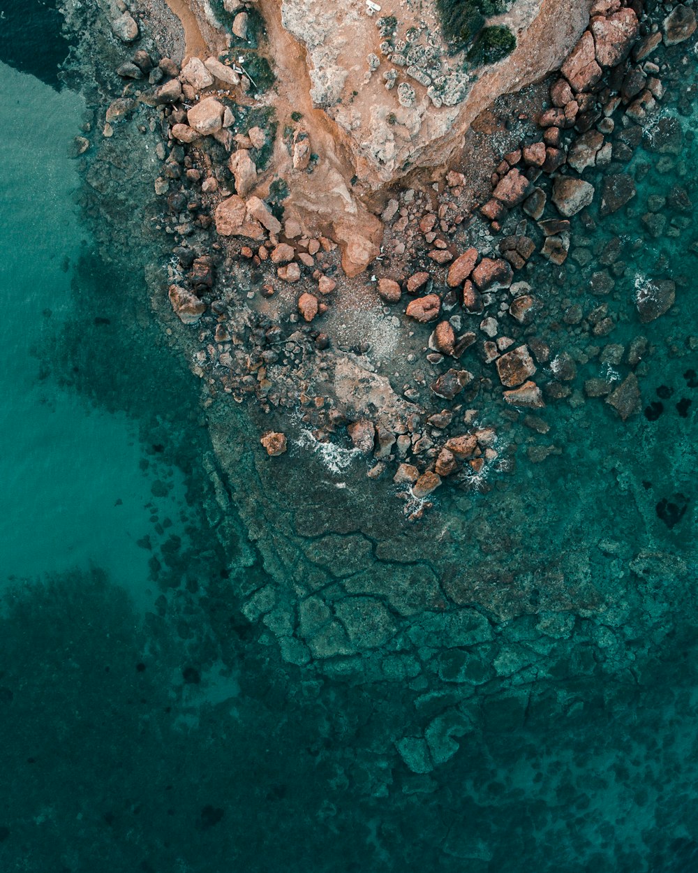 brown rocks on body of water