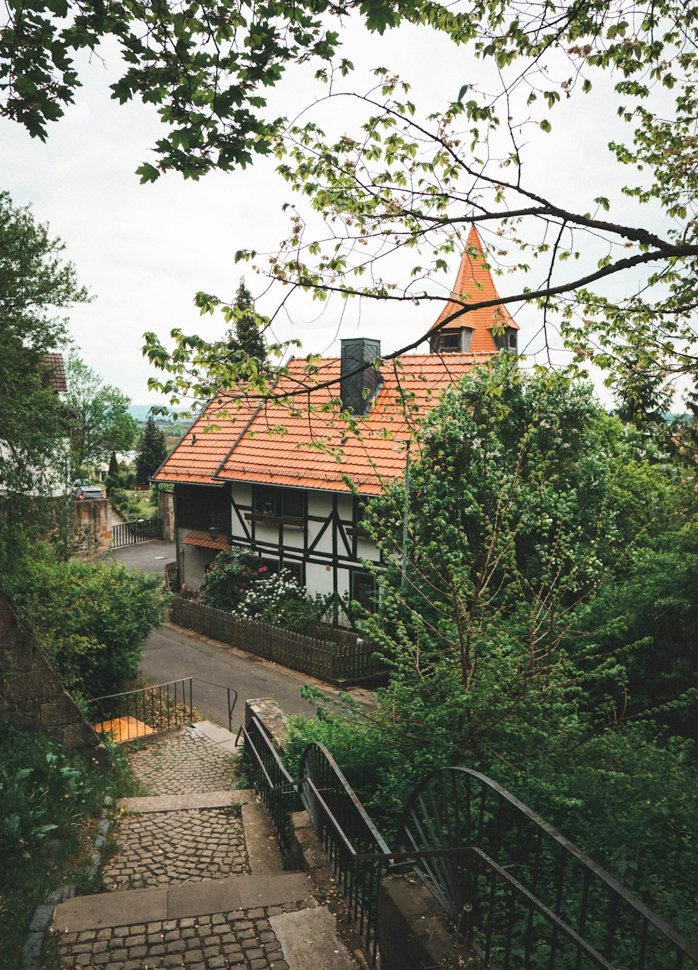 brown and white concrete house surrounded by green trees during daytime