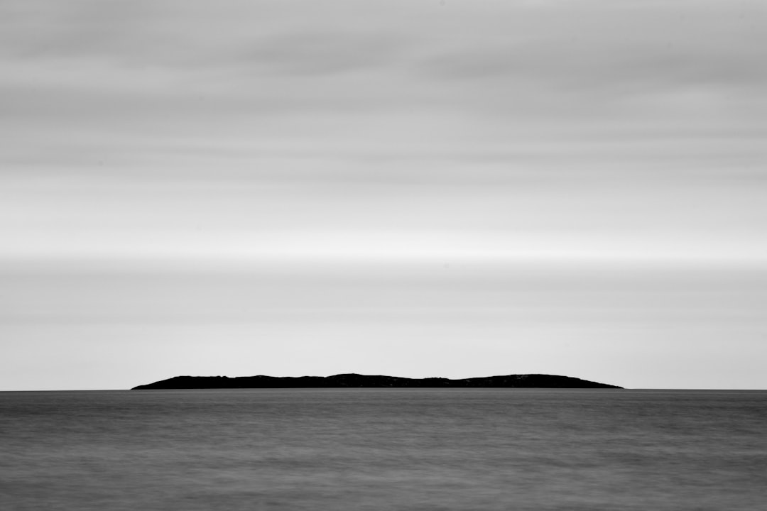 body of water under cloudy sky during daytime