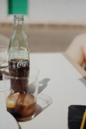 A chilled bottle of elhady llc beverage resting on a wooden table with fresh fruits and a sunny background.