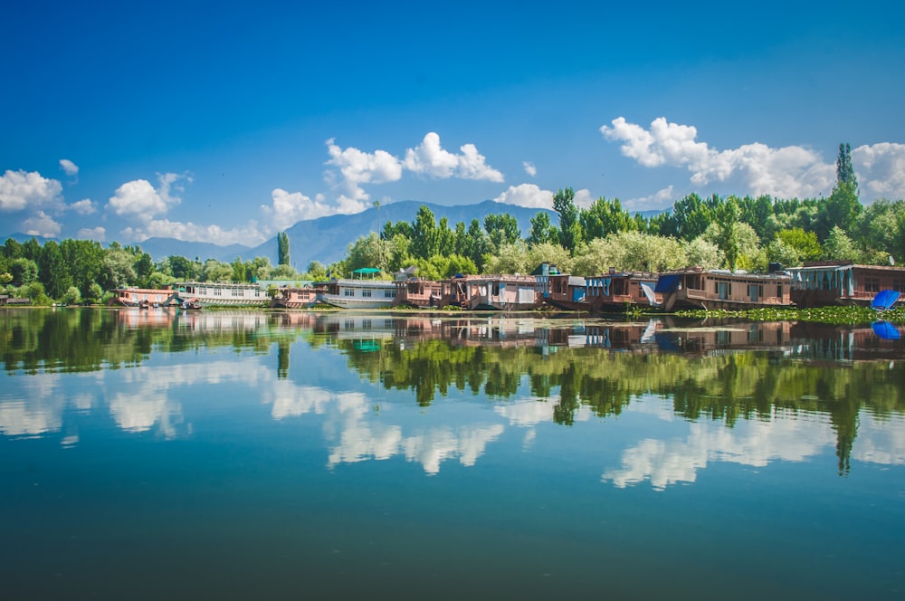 brown wooden houses near body of water under blue sky during daytime