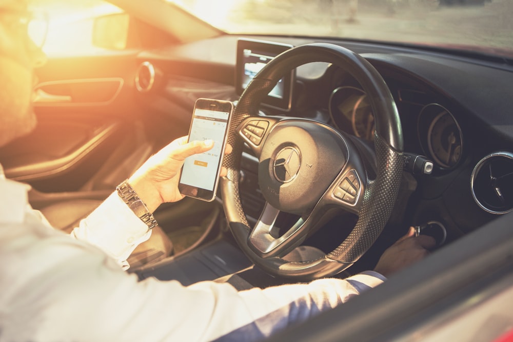 person holding black and silver steering wheel