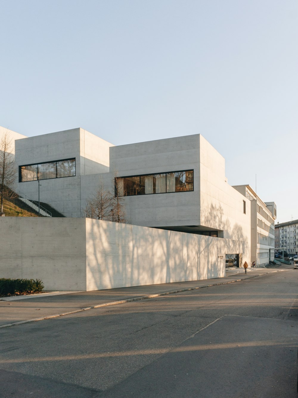 bâtiment en béton blanc près d’arbres dénudés pendant la journée