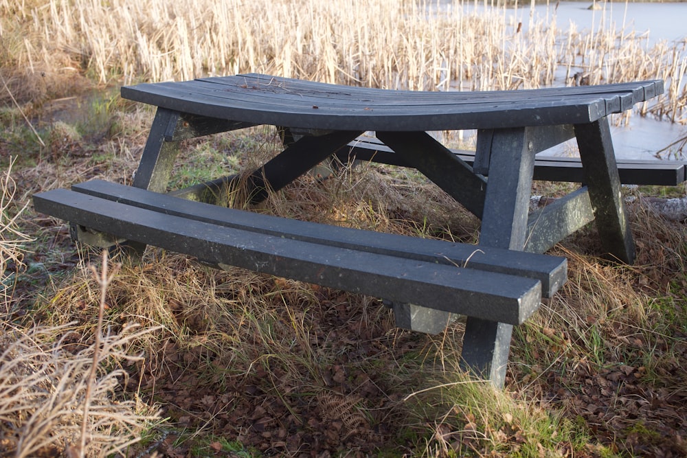 brown wooden picnic table on brown grass field during daytime