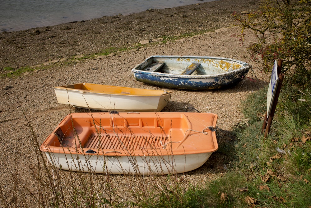 orange and white boat on green grass during daytime